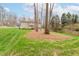 Well-maintained backyard with manicured lawn and mature trees providing privacy and shade at 415 King George Loop, Cary, NC 27511