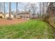 Spacious backyard with lush green grass and mature trees, a wooden fence at 415 King George Loop, Cary, NC 27511