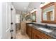 Bathroom with double sink granite vanity, framed mirrors, and tiled shower stall at 415 King George Loop, Cary, NC 27511