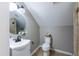Bathroom featuring stylish vanity, round mirror, a toilet with a basket, and a shower with glass doors at 415 King George Loop, Cary, NC 27511