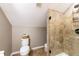 Bathroom area showcasing a toilet with a basket, ceramic tile flooring and walls, and a shower at 415 King George Loop, Cary, NC 27511