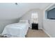 Cozy bedroom with a sloped ceiling, featuring a single bed, bedside table, and built-in TV niche at 415 King George Loop, Cary, NC 27511