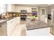 Well-appointed kitchen with stainless steel appliances, tile floors, and a large center island at 415 King George Loop, Cary, NC 27511