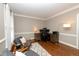 A well-lit office space with a desk setup and hardwood floors, with a comfortable seating area at 415 King George Loop, Cary, NC 27511