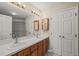 Bright bathroom featuring a double vanity with wood cabinets, neutral walls, and a large mirror at 42 Renwick Ct, Raleigh, NC 27615