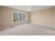 Cozy bedroom with neutral walls, plush carpet, and a large window offering natural light at 42 Renwick Ct, Raleigh, NC 27615