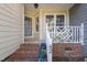 Cozy front porch with brick steps, flower pots, and a white railing at 42 Renwick Ct, Raleigh, NC 27615
