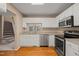 Functional kitchen with stainless steel appliances, white cabinets, and wood flooring at 42 Renwick Ct, Raleigh, NC 27615