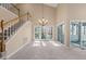 Bright living room featuring a staircase, large windows, and sliding glass doors at 42 Renwick Ct, Raleigh, NC 27615