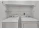 Functional laundry space featuring a white washer and dryer set with shelving for storage at 4622 Vendue Range Dr, Raleigh, NC 27604