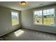 Bedroom featuring two large windows providing natural light and neutral carpeting at 511 Valentine Ct, Graham, NC 27253