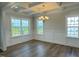 Bright dining room featuring coffered ceilings, wood floors, classic chandelier, and large windows at 511 Valentine Ct, Graham, NC 27253