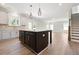 Spacious kitchen with a dark island, hardwood floors, stainless steel appliances, and an open layout at 511 Valentine Ct, Graham, NC 27253