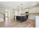 Stylish kitchen with a dark island, white cabinets, stainless steel appliances, and hardwood floors at 511 Valentine Ct, Graham, NC 27253