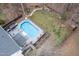 Backyard featuring a swimming pool, deck area with outdoor furniture, surrounded by lush greenery and mature trees at 512 Tryst Ln, Wake Forest, NC 27587