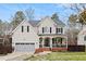 Charming two-story home with a welcoming front porch, well-maintained lawn, and attached garage at 512 Tryst Ln, Wake Forest, NC 27587
