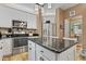 Bright kitchen with white cabinets, stainless steel appliances, mosaic backsplash, and large island at 512 Tryst Ln, Wake Forest, NC 27587