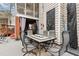 Covered patio with gray furniture, string lights, and outdoor art; a perfect relaxing outdoor space at 512 Tryst Ln, Wake Forest, NC 27587