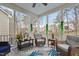 Screened-in porch with wicker chairs, ceiling fan, and greenery for a relaxing outdoor experience at 512 Tryst Ln, Wake Forest, NC 27587