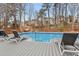 Inviting in-ground pool with deck, surrounded by lush greenery, offers a refreshing backyard escape at 512 Tryst Ln, Wake Forest, NC 27587