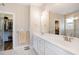 Bathroom featuring dual sinks, ample lighting, and a view of a walk-in closet at 560 Waterstone Ln, Henderson, NC 27537