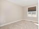 Clean and well-lit bedroom featuring carpeted floors and a window at 560 Waterstone Ln, Henderson, NC 27537