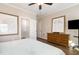 Bedroom featuring hardwood floors, a ceiling fan, and a view to an ensuite bathroom at 560 Waterstone Ln, Henderson, NC 27537