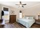 Cozy bedroom with hardwood floors, a ceiling fan, and ample natural light from two windows at 560 Waterstone Ln, Henderson, NC 27537