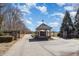 Gated entrance with a stone and beige gazebo on a paved road leading to the property and surrounding greenery at 560 Waterstone Ln, Henderson, NC 27537