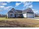 Charming single-Gathering home boasts light blue siding, a well-manicured lawn, and a two-car garage at 560 Waterstone Ln, Henderson, NC 27537