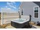 Hot tub featuring a cover surrounded by a white lattice fence, creating a private backyard space for relaxation at 560 Waterstone Ln, Henderson, NC 27537