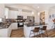 Modern kitchen featuring white cabinets, a stainless steel refrigerator, and granite countertops with barstool seating at 560 Waterstone Ln, Henderson, NC 27537