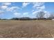 Expansive property featuring a vast field with a blue sky and fluffy white clouds on a sunny day at 560 Waterstone Ln, Henderson, NC 27537