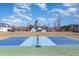 Backyard featuring a blue and green tennis court and a view of the home on a partially cloudy day at 560 Waterstone Ln, Henderson, NC 27537
