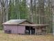 Exterior view of a barn with animal pens and an open stall, set amidst a wooded backdrop at 577 Dixon Rd # D, Willow Springs, NC 27592