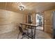Rustic dining area features wood paneling, a dining table, and an entryway to the home at 577 Dixon Rd # D, Willow Springs, NC 27592