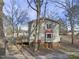 Rear view of a gray two-story home with a red metal roof and bay window, nestled among bare trees at 577 Dixon Rd # D, Willow Springs, NC 27592
