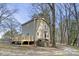 Side view of a two-story home featuring a wooden deck and unique round window, blending with the natural landscape at 577 Dixon Rd # D, Willow Springs, NC 27592