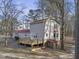 Charming two-story home with a wooden deck and a red metal roof, surrounded by mature trees at 577 Dixon Rd # D, Willow Springs, NC 27592