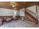 Inviting living room featuring a leather sofa, wooden ceiling, and staircase, perfect for relaxing and entertaining at 577 Dixon Rd # D, Willow Springs, NC 27592
