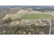 Expansive property featuring a charming home surrounded by lush trees and well-manicured fields with a small lake in the distance at 582 Ebenezer Church Rd, Coats, NC 27521
