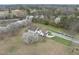 Aerial view of country home with brown roof, blossoming trees, and a long driveway at 582 Ebenezer Church Rd, Coats, NC 27521
