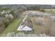 Aerial view features white home with brown roof, complemented by blooming trees and scenic surroundings at 582 Ebenezer Church Rd, Coats, NC 27521