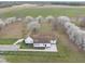 Aerial view showcases house with green fields, blossoming trees, and a brown roof at 582 Ebenezer Church Rd, Coats, NC 27521