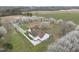 Aerial view of white house with brown roof, well manicured landscaping, and blossoming trees at 582 Ebenezer Church Rd, Coats, NC 27521