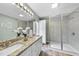 Modern bathroom with dual sinks, granite counters, tiled shower, and ample storage at 582 Ebenezer Church Rd, Coats, NC 27521