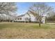 Charming white home with a beautiful yard, flowering trees, and a gated driveway at 582 Ebenezer Church Rd, Coats, NC 27521