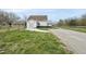 Side exterior view of a house with a garage, long driveway and green lawn at 582 Ebenezer Church Rd, Coats, NC 27521