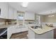 Bright eat-in kitchen area with granite counters, white cabinets, and two windows for natural light at 582 Ebenezer Church Rd, Coats, NC 27521