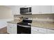 Kitchen with granite countertops, stainless steel appliances including range and microwave, and white cabinetry at 582 Ebenezer Church Rd, Coats, NC 27521